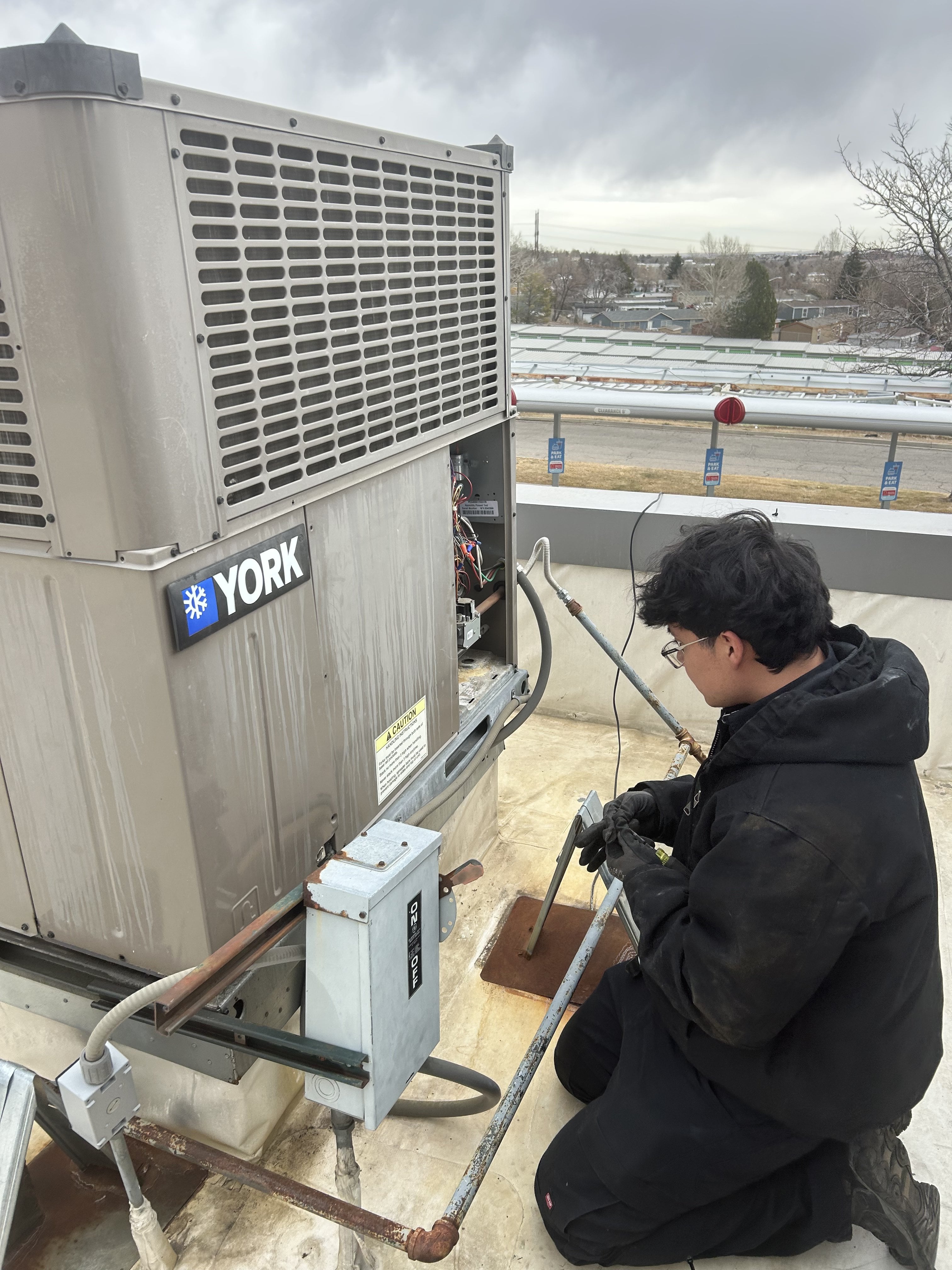 Technician servicing commercial HVAC equipment